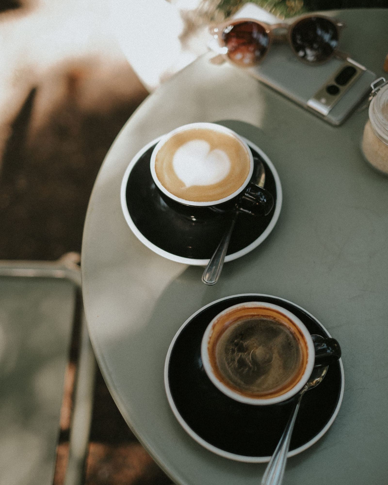 Two coffees on a café table outdoors