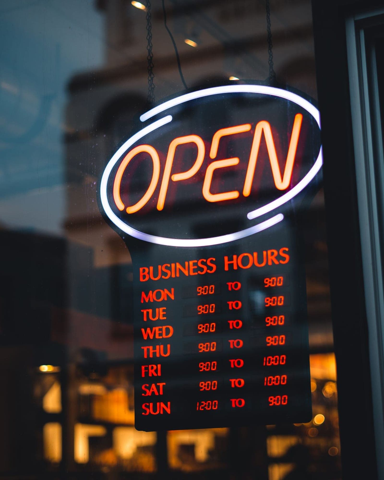 A lit OPEN sign in a shop window at night